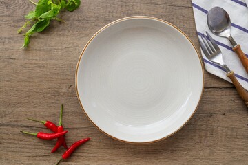 white ceramic empty plate with spoon and fork   on wooden  table