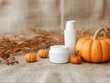 © pprothien - Cozy autumn composition with skincare products and pumpkins, perfect for seasonal beauty and wellness themes.