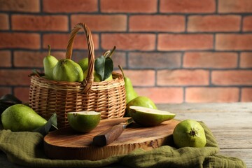 Sticker - Fresh green pears and knife on wooden table against brick wall. Space for text