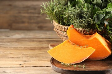 Wall Mural - Different fresh herbs and pumpkin on wooden table, closeup. Space for text