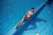 © standret - View from the top, lying down. Beautiful woman in bikini is resting by the pool