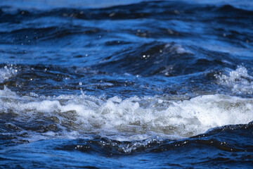 Wall Mural - Sea waves with white foam are on blue shore water