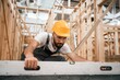 © standret - Checking the straight by using leveling tool. Industrial worker in wooden warehouse