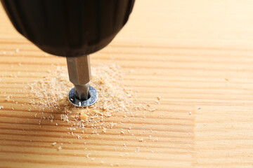 Wall Mural - Screwing screw into wooden plank, closeup view