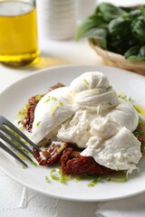 Delicious burrata cheese and sun-dried tomatoes served on white table, closeup