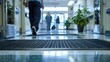 © ArmStrong☠ - A low angle view of a black rubber mat in a hospital hallway with people walking by in the background.