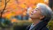 © john - Japanese elderly woman breathing a fresh air in the park, meditation