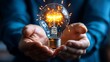 © Raitalinn - A hand holds a glowing light bulb surrounded by sparks, embodying the concept of inspiration and new ideas.