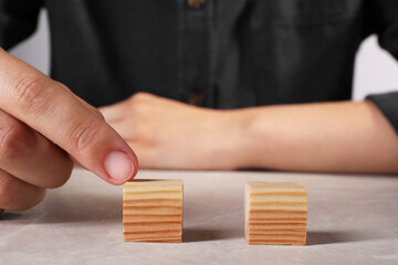 Canvas Print - Woman with wooden cubes at light table, closeup