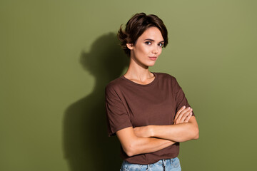 Wall Mural - Photo of smart intelligent girl wear oversize t-shirt holding palms crossed near empty space logo isolated on green color background