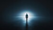 © Naphol - A solitary figure stands in the darkness, illuminated by a bright light, symbolizing hope and introspection in a mysterious environment.