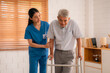 © chokniti - young asian female nurse care giver helping asian senior old man with mobility walker in living area of nursing home senior daycare center,Nurse take care elderly patient with cheerful concentrate