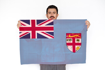 Young man holding Fiji flag, protest or social issues in Fiji, two hands and white background