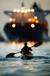 © Joyce - A person kayaking in tropical sea water with cargo ship