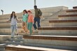© Seventyfour - Wide angle shot of diverse group of college students hanging out outdoors walking down stairs of amphitheater as teenage boy telling friends gripping story