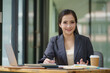 © Songsak C - Confident young businesswoman looking at the camera while sitting at her workspace.