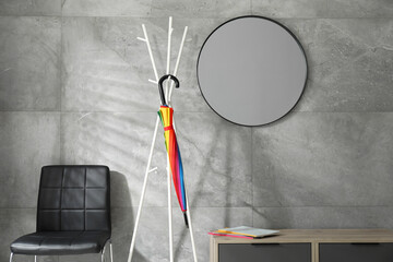 Wall Mural - Bright umbrella on clothing rack at home