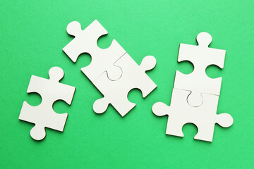 Wall Mural - White puzzle pieces on green background, top view