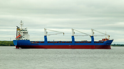 A large cargo sea vessel is at anchor, a dry cargo ship is at anchor