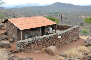 Wall Mural - Stone House in Rural Landscape with Mountains in the Background