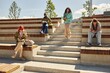 © Seventyfour - Full length shot of teenage girl with curly hair walking down stairs of amphitheater, where students reading books and using phones while staying in sun outside on campus