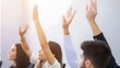 © Felippe Lopes - Diverse group of people raising hands during a meeting or seminar in a bright room.