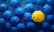 © Handz - A single yellow umbrella stands out among a sea of blue umbrellas.