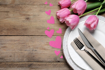 Sticker - Table setting for romantic Valentine's day celebration, top view. Plates, cutlery, flowers and hearts on wooden table, space for text