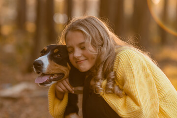 little teenage girl walks with her dog in the autumn in the forest