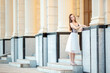 © Vera - Young smiling girl walking around the city. Girl with light brown hair in summer clothes posing against the background of ancient historical buildings of Venetian style.