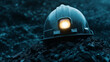 © fotogurmespb - Coal miner’s helmet with a lit headlamp placed on a pile of coal, black dust particles floating in dim light