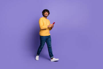 Poster - Photo of cheerful cool latin man wear trendy yellow clothes hold modern gadget isolated on purple color background