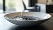 © SashaMagic - White bowl with swirling black liquid on modern table.