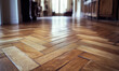 © Ikhou - A parquet floor with a chevron pattern, showcasing the beauty of wood flooring in an elegant setting
