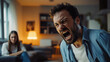 © Frank Gärtner - Man furiously yelling with his eyes shut as his girlfriend sits on the couch in the background