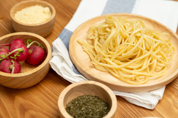 Health food's recipe ingredients of special menu homemade cooking raw spaghetti with tomato sauce and basil of macro photo shooting placing elements on preparing wooden blurred background. Postulate.