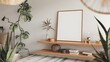 © Basiouny.Basiouny - A modern living room with a white wall and a wooden shelf. There is a square empty mock-up poster frame on the shelf.