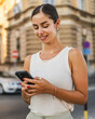 © Miljan Živković - Young woman stand on the street and use mobile phone