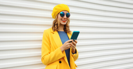 Wall Mural - Autumn portrait of stylish happy smiling young woman with phone, beautiful girl holding smartphone