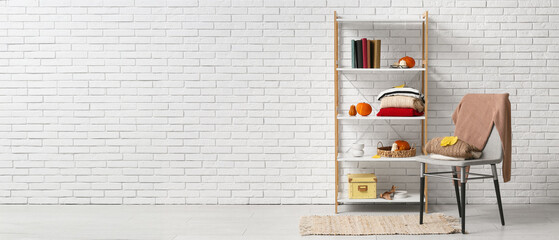 Canvas Print - Interior of room with autumn decor and sweaters on chair and shelf unit