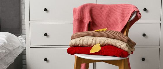 Canvas Print - Warm sweaters with autumn leaves on chair in bedroom