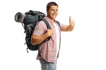 Male backpacker carrying backpack with equipment and gesturing thumbs up