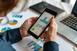 © kitipol - Professionals using mobile devices for financial analytics, collaborative workspace, charts and graphs