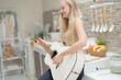 © ultramansk - A musician woman plays an acoustic guitar in a bright kitchen, combining the themes of domestic life and artistic expression, reflecting a relaxed lifestyle focused on creativity and comfort.