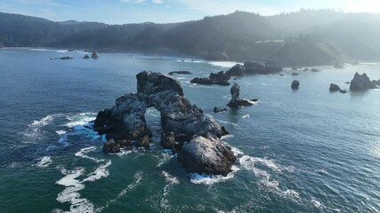 Sticker - The Pacific Ocean surrounds rugged sea stacks found just off the scenic coast of northern Oregon near Cannon Beach. This beautiful area is a popular destination during summer months.