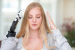 © ultramansk - A young woman is using a robotic prosthetic arm hand attached to her body to work on a desk. she is doing computer document and communication work. woman tries to control the smart arm in her home.