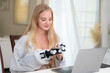 © ultramansk - A young woman is using a robotic prosthetic arm hand attached to her body to work on a desk. she is doing computer document and communication work. woman tries to control the smart arm in her home.
