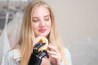 © ultramansk - A young woman is using a robotic prosthetic arm attached to her body. She controls her hand to pick up objects food donut. The woman tries to control the smart arm in her home.