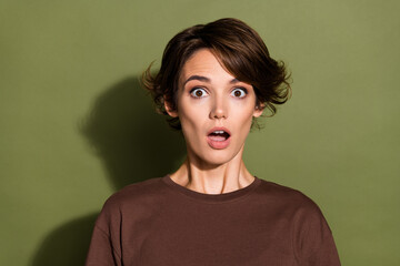 Wall Mural - Portrait of impressed girl with short hairstyle wear oversize t-shirt astonished staring open mouth isolated on green color background