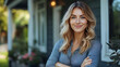 © Siasart Studio - Portrait of a smiling young woman standing outside a house, looking at the camera.